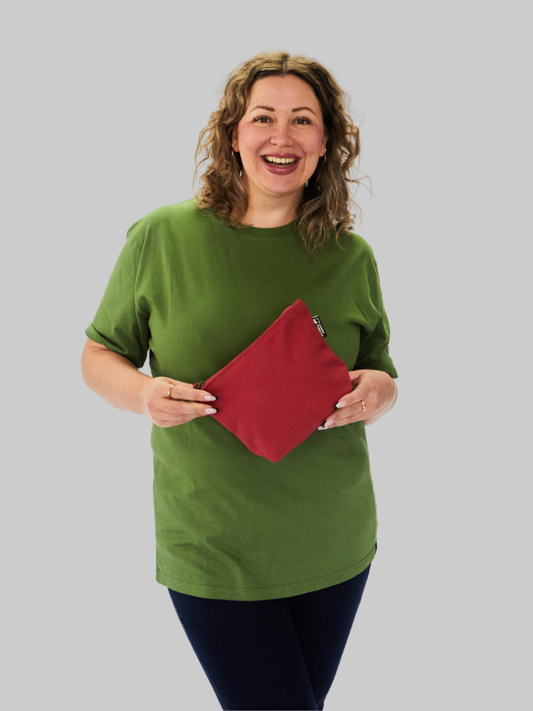 Model holding a sustainable red makeup bag