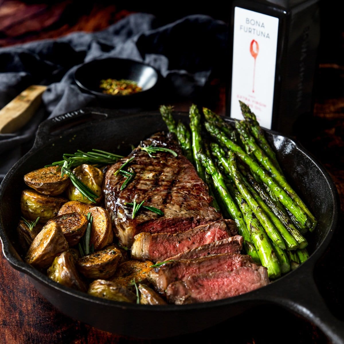 Ribeye steak and sides with olive oil bottle